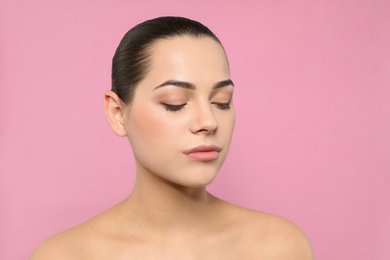 Photo of Portrait of young woman with beautiful face and natural makeup on color background