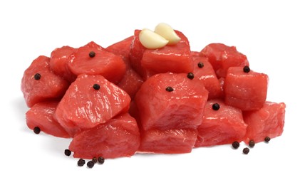 Pieces of raw beef, peppercorns and garlic isolated on white