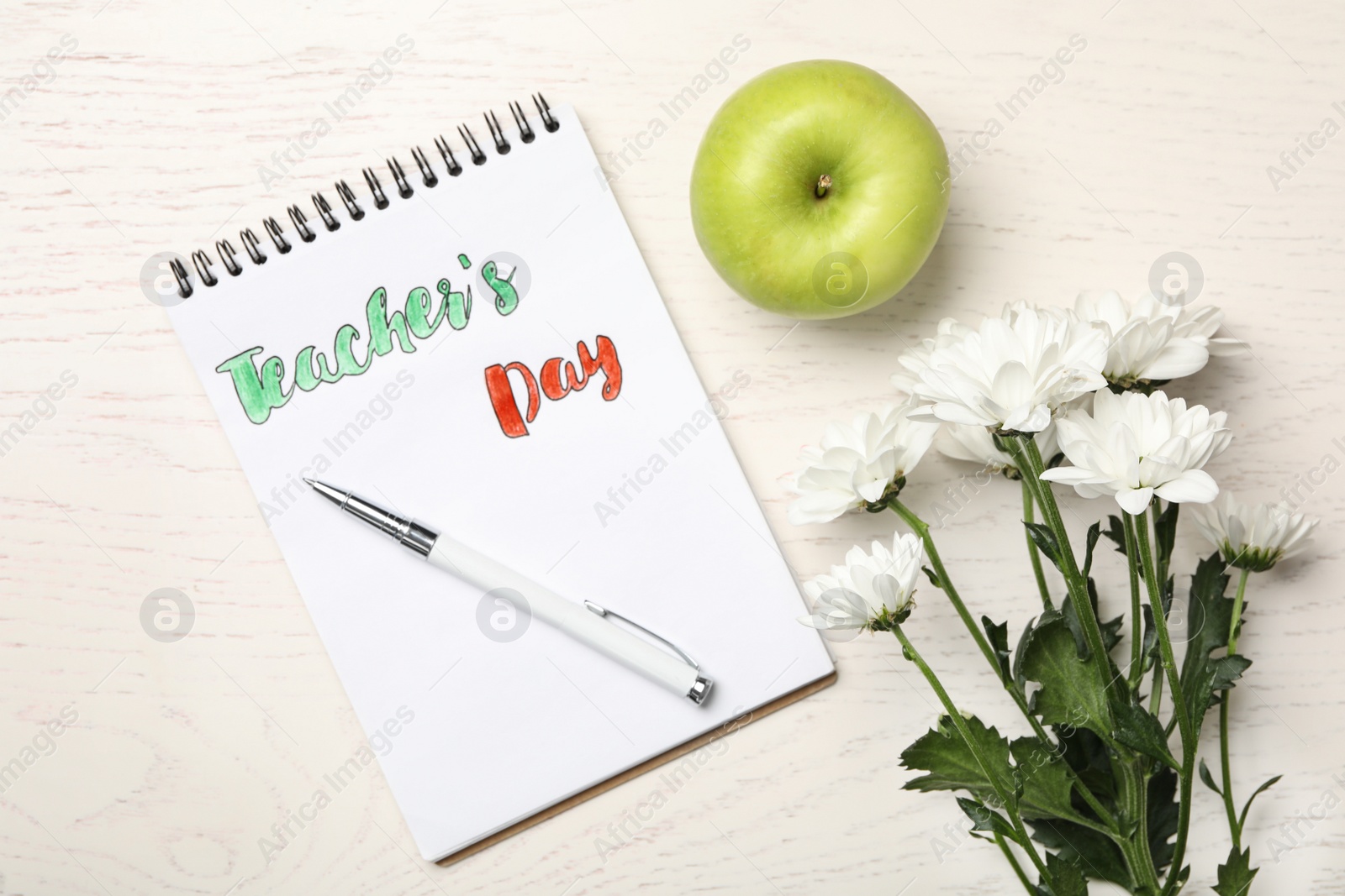 Photo of Flat lay composition with words TEACHER'S DAY, flowers and apple on white wooden table