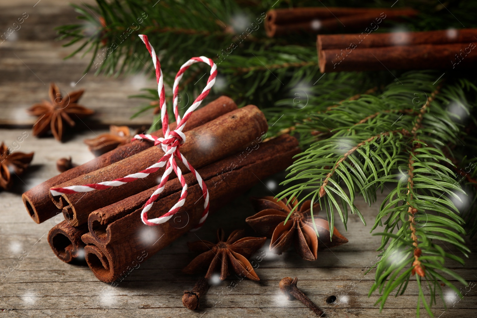 Image of Different spices and fir tree branches on wooden table, closeup. Cinnamon, anise, cloves