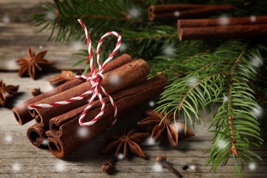 Image of Different spices and fir tree branches on wooden table, closeup. Cinnamon, anise, cloves