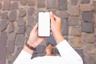 Photo of Closeup of woman with smartphone outdoors, above view