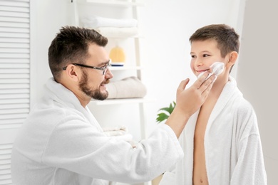 Dad teaching his son to shave in bathroom