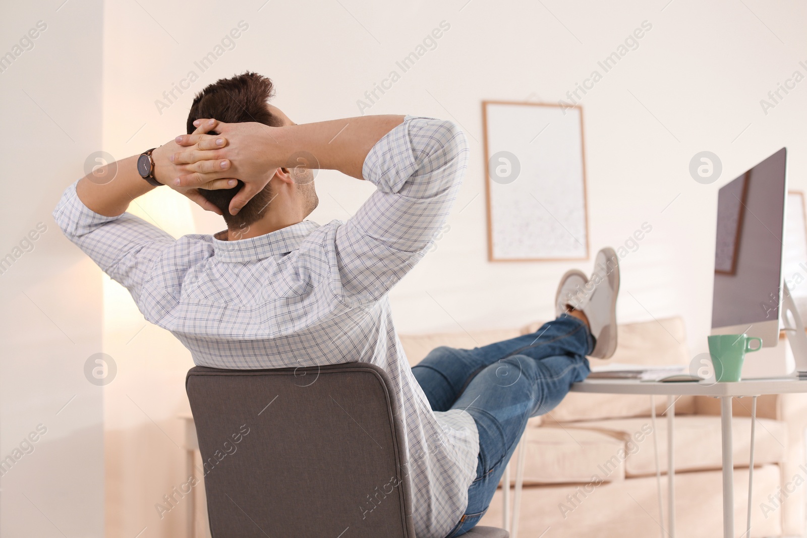 Photo of Young man relaxing at table in office during break