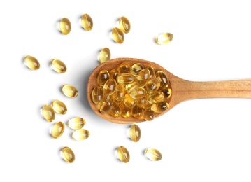 Spoon with cod liver oil pills on white background, top view