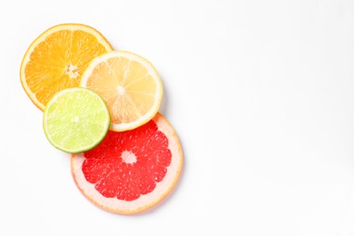 Photo of Slices of fresh ripe citrus fruits on white background, flat lay. Space for text
