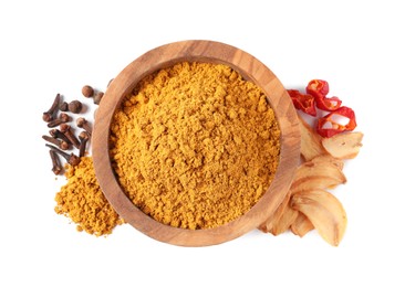 Dry curry powder in bowl and other spices isolated on white, top view