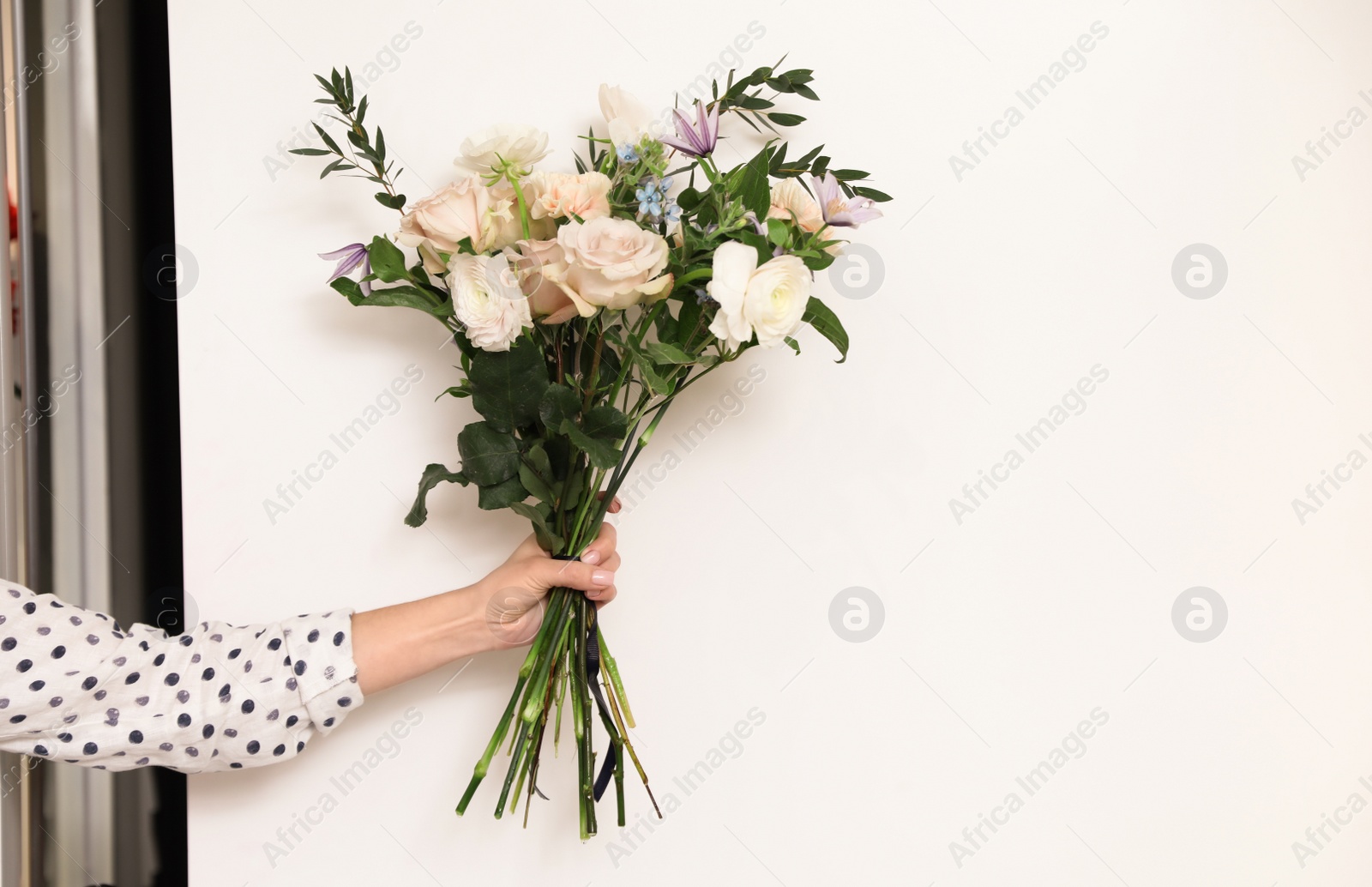 Photo of Professional florist with bouquet of fresh flowers in shop, closeup