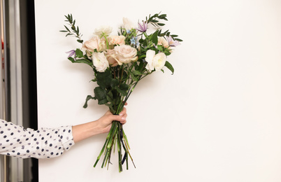 Photo of Professional florist with bouquet of fresh flowers in shop, closeup