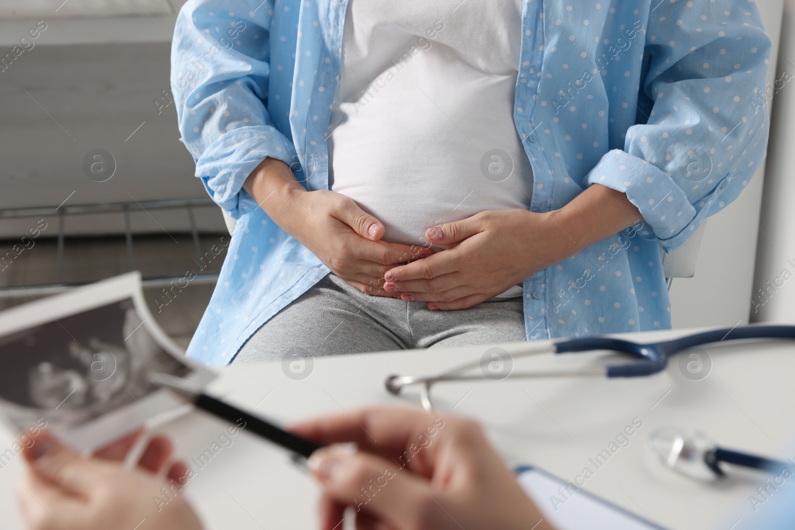 Photo of Pregnant woman having doctor appointment in hospital, closeup