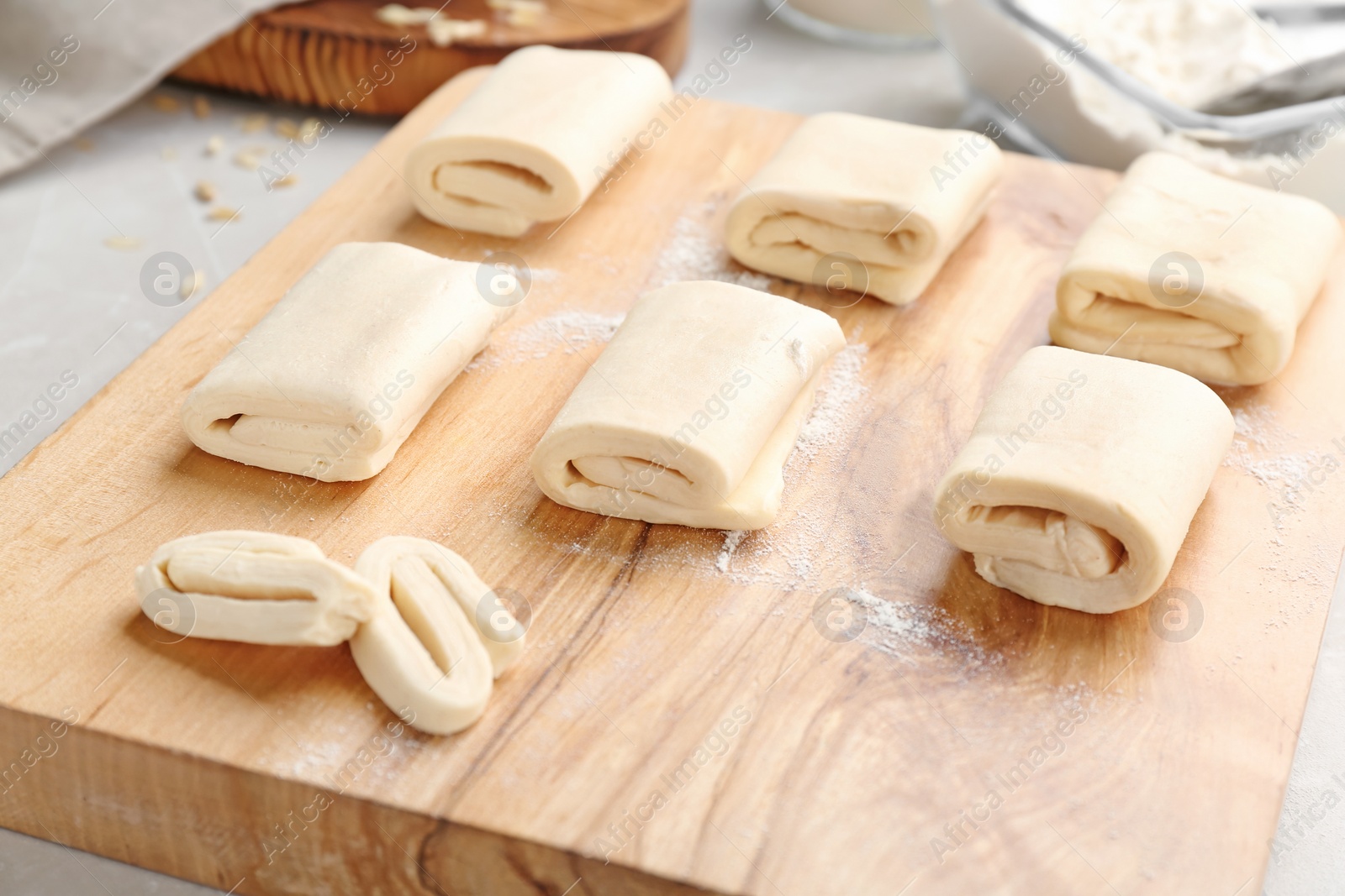 Photo of Wooden board with fresh dough, closeup. Puff pastry