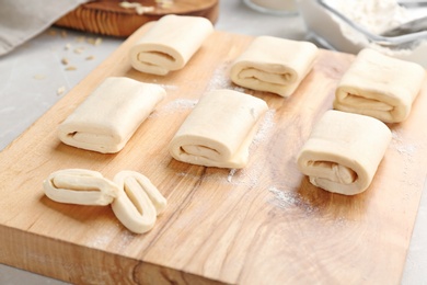 Photo of Wooden board with fresh dough, closeup. Puff pastry