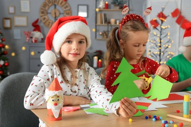 Cute little children making beautiful Christmas greeting cards at home