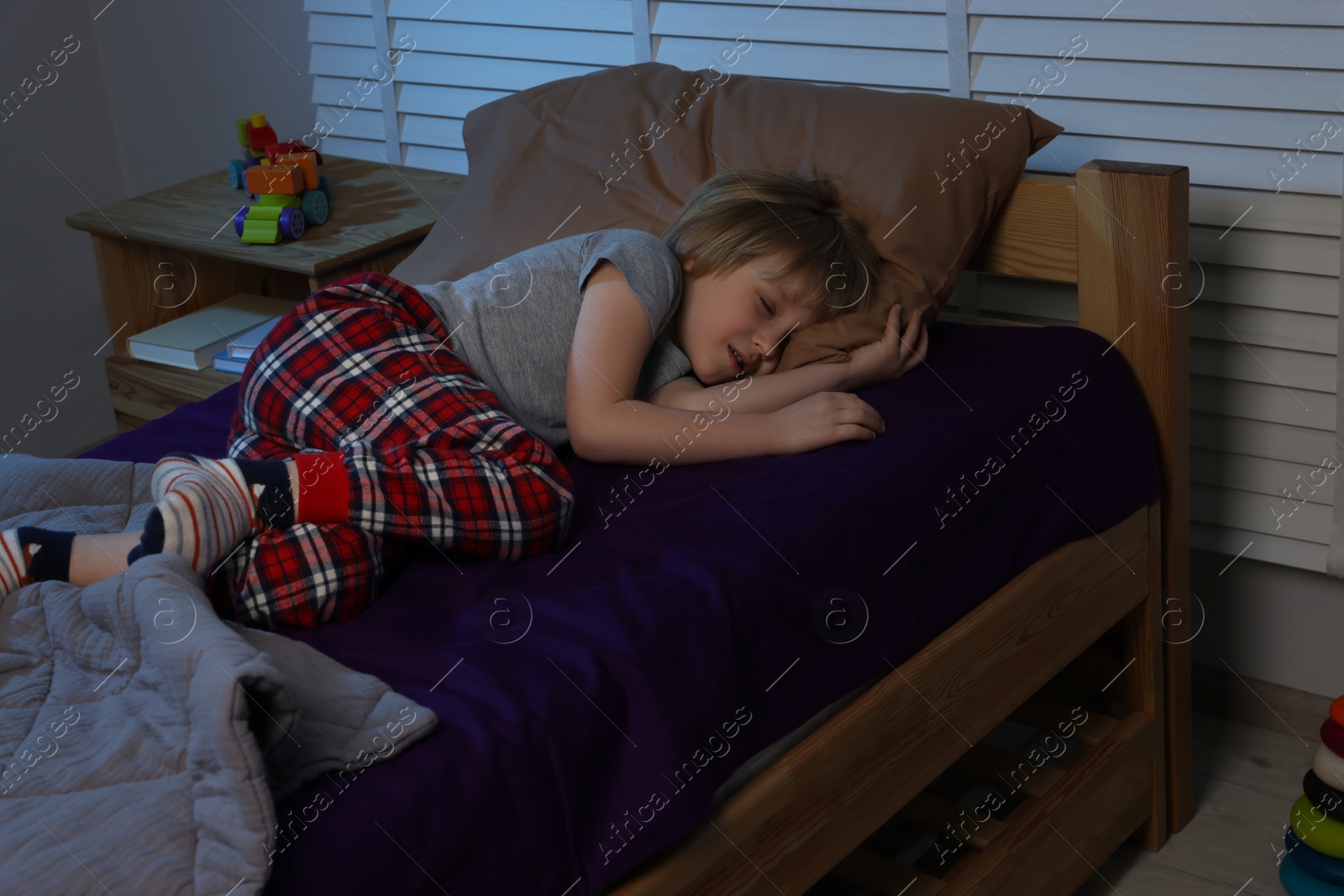 Photo of Little boy snoring while sleeping on bed at night