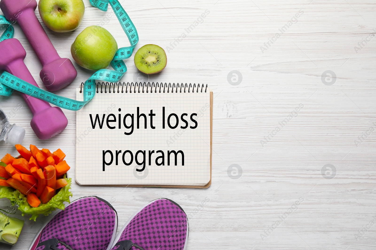 Photo of Weight loss concept. Flat lay composition with notebook, sneakers and different products on white wooden table, space for text