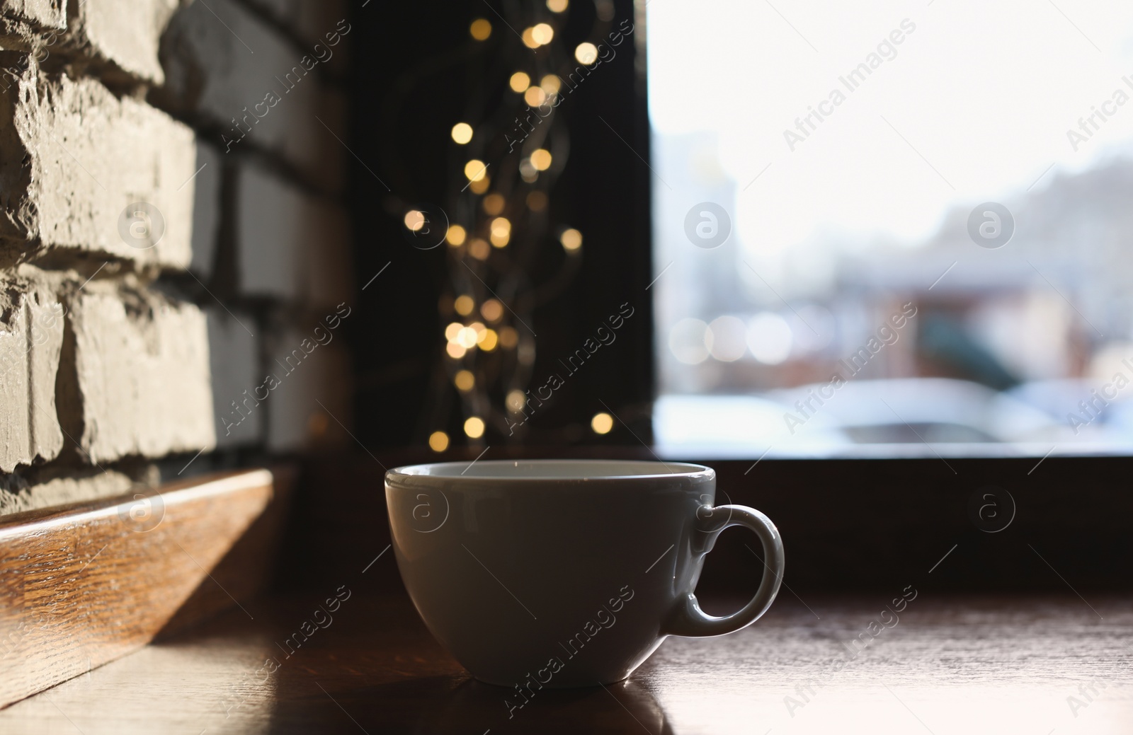 Photo of Delicious morning coffee near brick wall indoors