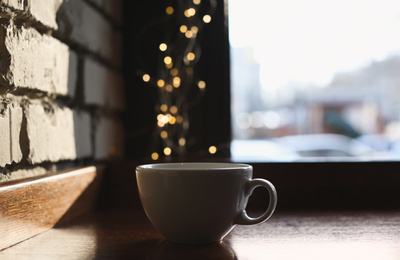 Delicious morning coffee near brick wall indoors