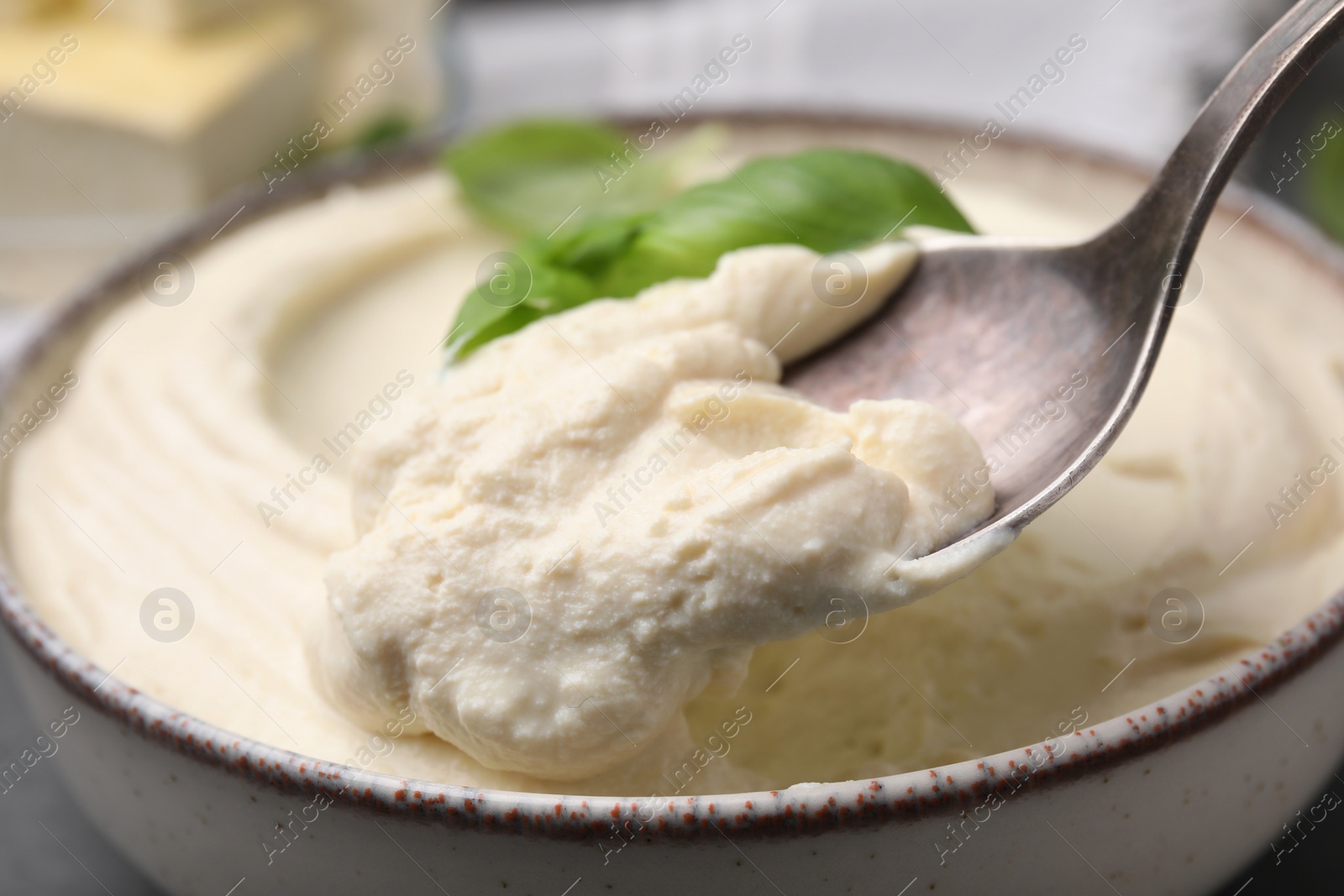 Photo of Taking delicious tofu sauce with spoon at table, closeup