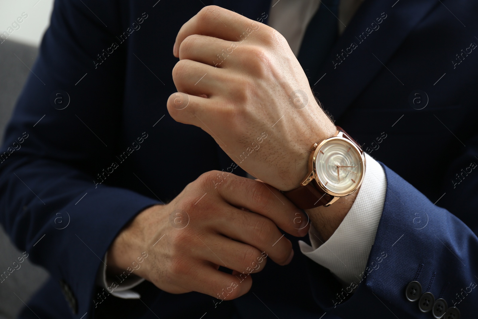 Photo of Businessman in jacket with luxury wrist watch, closeup