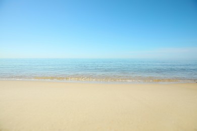 Photo of Beautiful sandy beach and sea under blue sky, closeup