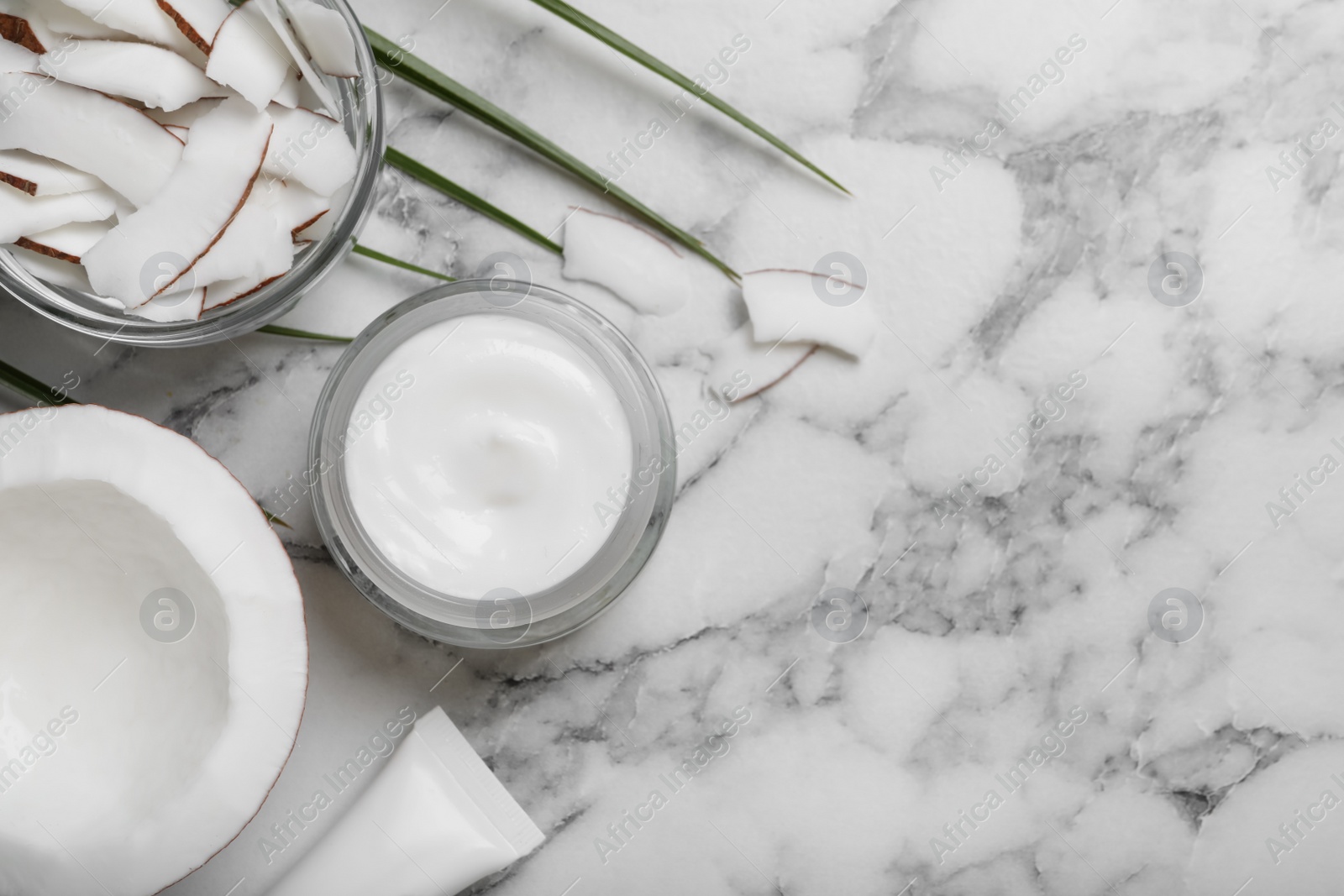 Photo of Jar of body cream with coconut on white marble table, flat lay. Space for text