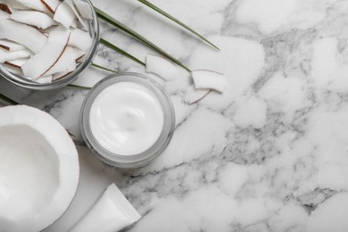 Jar of body cream with coconut on white marble table, flat lay. Space for text