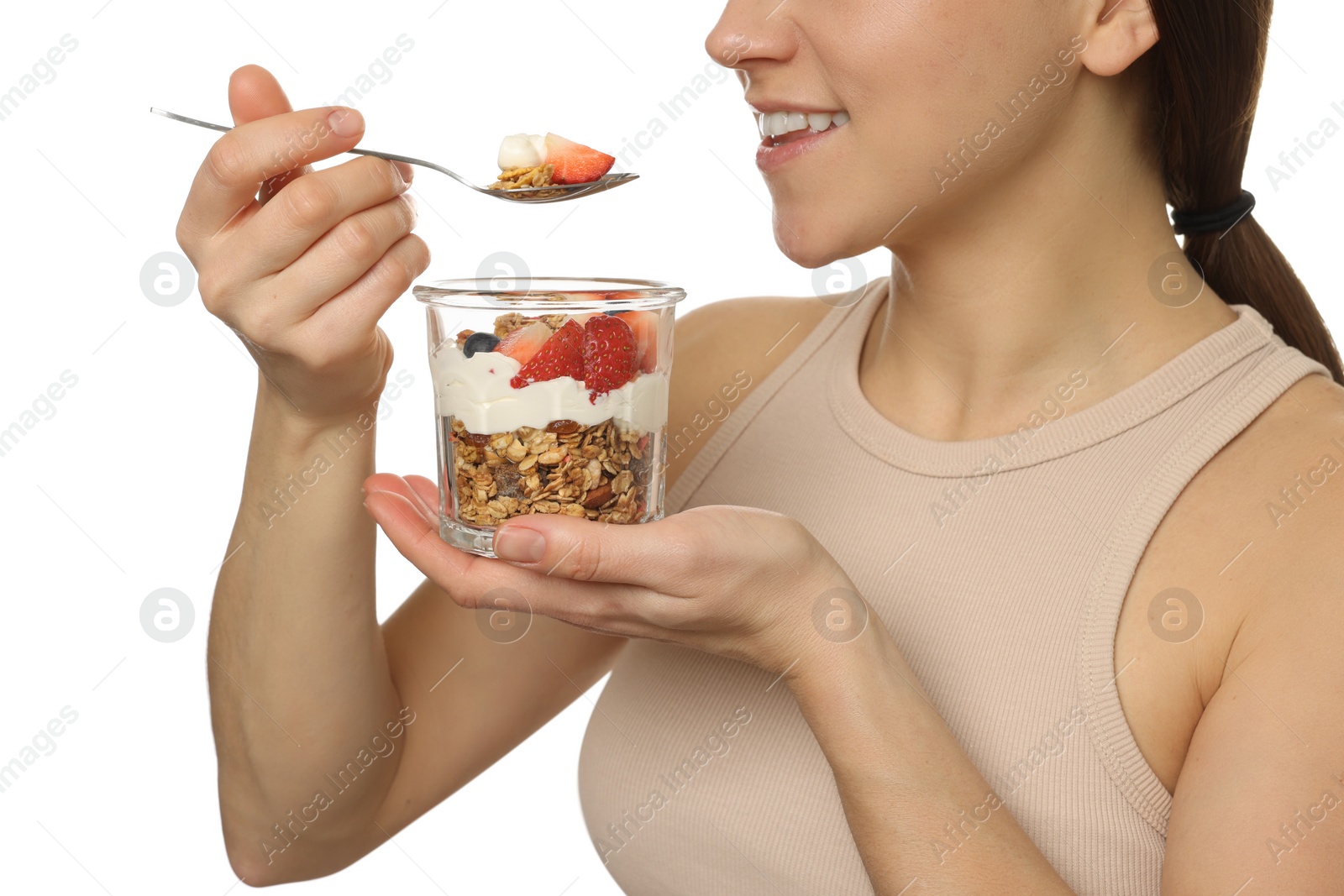 Photo of Happy woman eating tasty granola with fresh berries and yogurt on white background, closeup