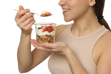 Photo of Happy woman eating tasty granola with fresh berries and yogurt on white background, closeup