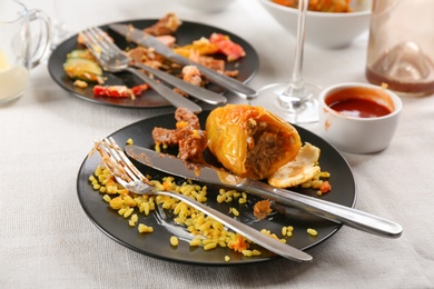 Photo of Food leftovers after party on table with cloth, closeup