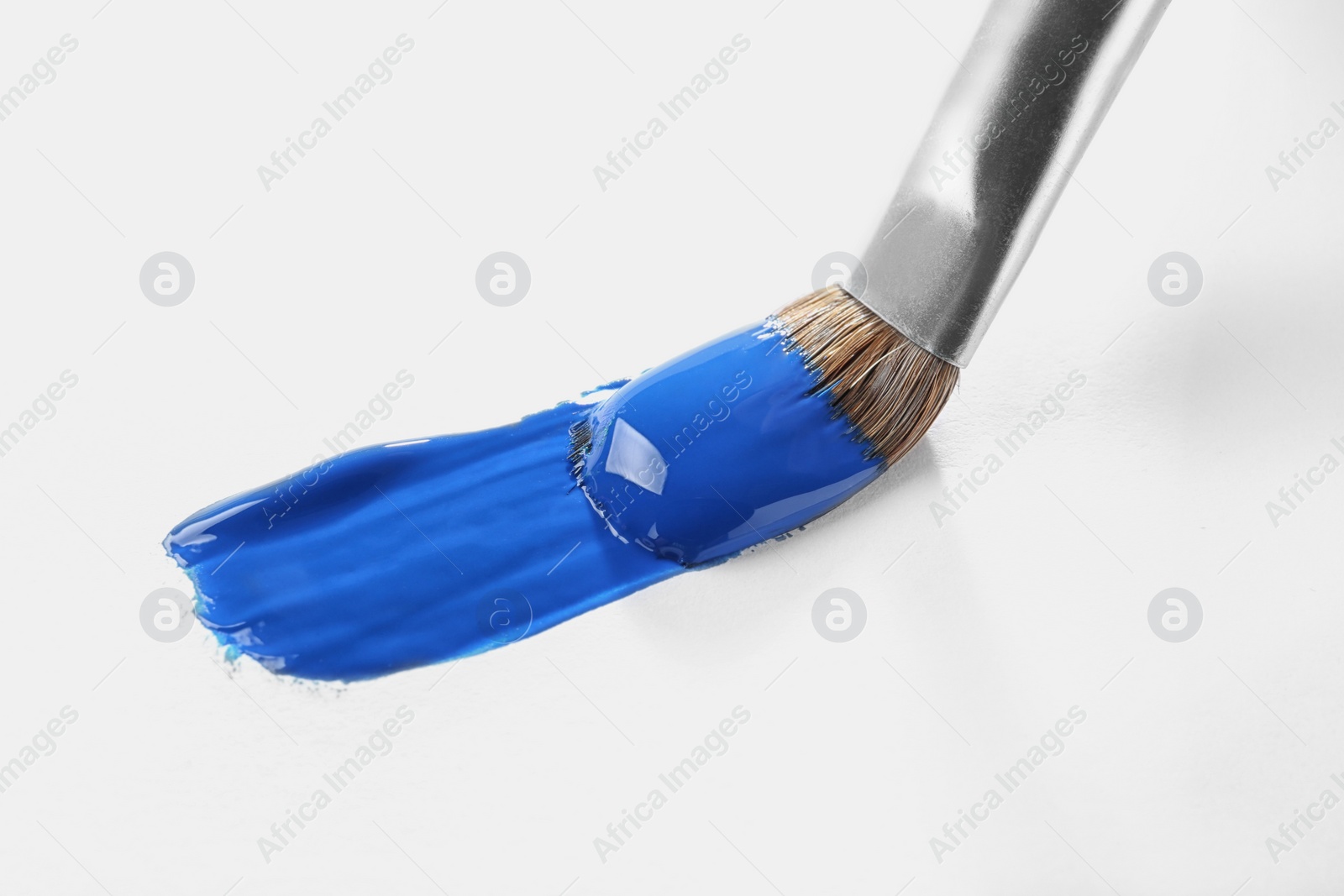 Photo of Brush with color paint and stroke on white background