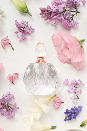 Photo of Luxury perfume and floral decor on white background, flat lay