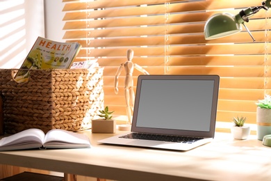 Photo of Comfortable workplace with laptop near window at home