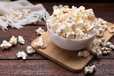 Bowl of tasty popcorn on wooden table