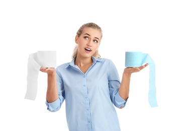 Beautiful young woman holding toilet paper rolls on white background