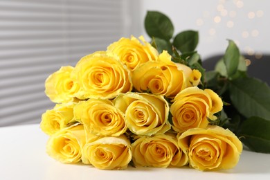 Beautiful bouquet of yellow roses on white table indoors, closeup