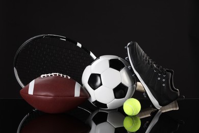 Photo of Many different sports equipment on black mirror surface