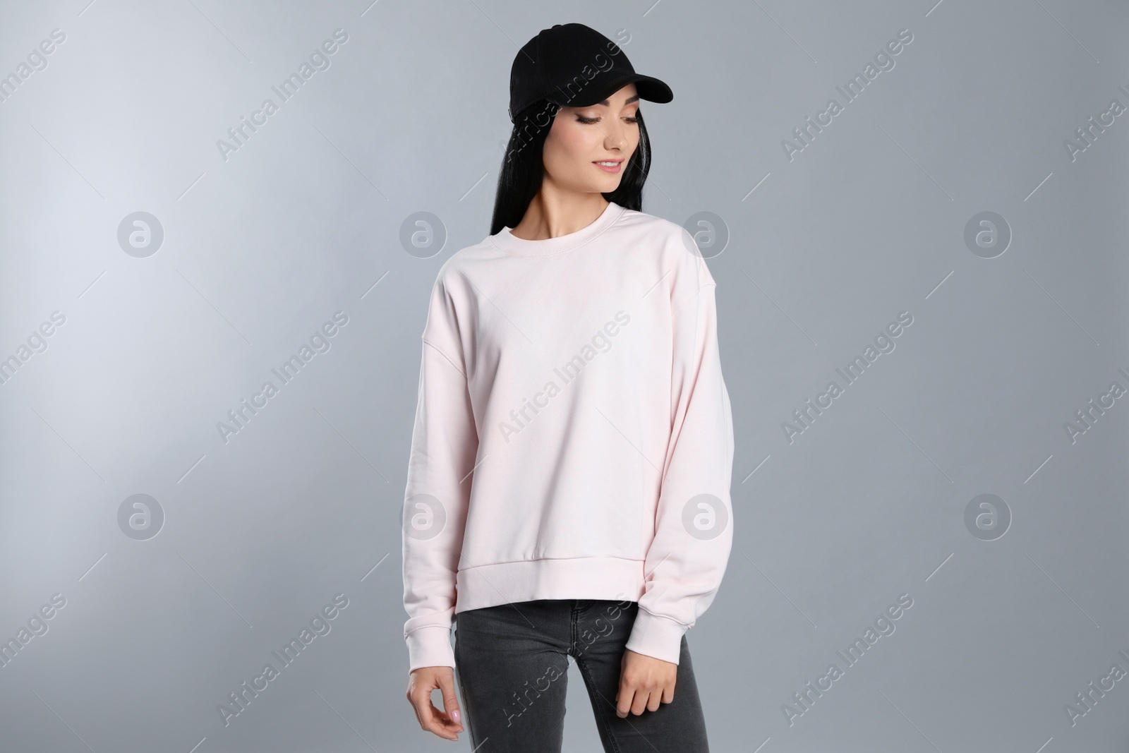 Photo of Portrait of young woman in sweater on grey background. Mock up for design