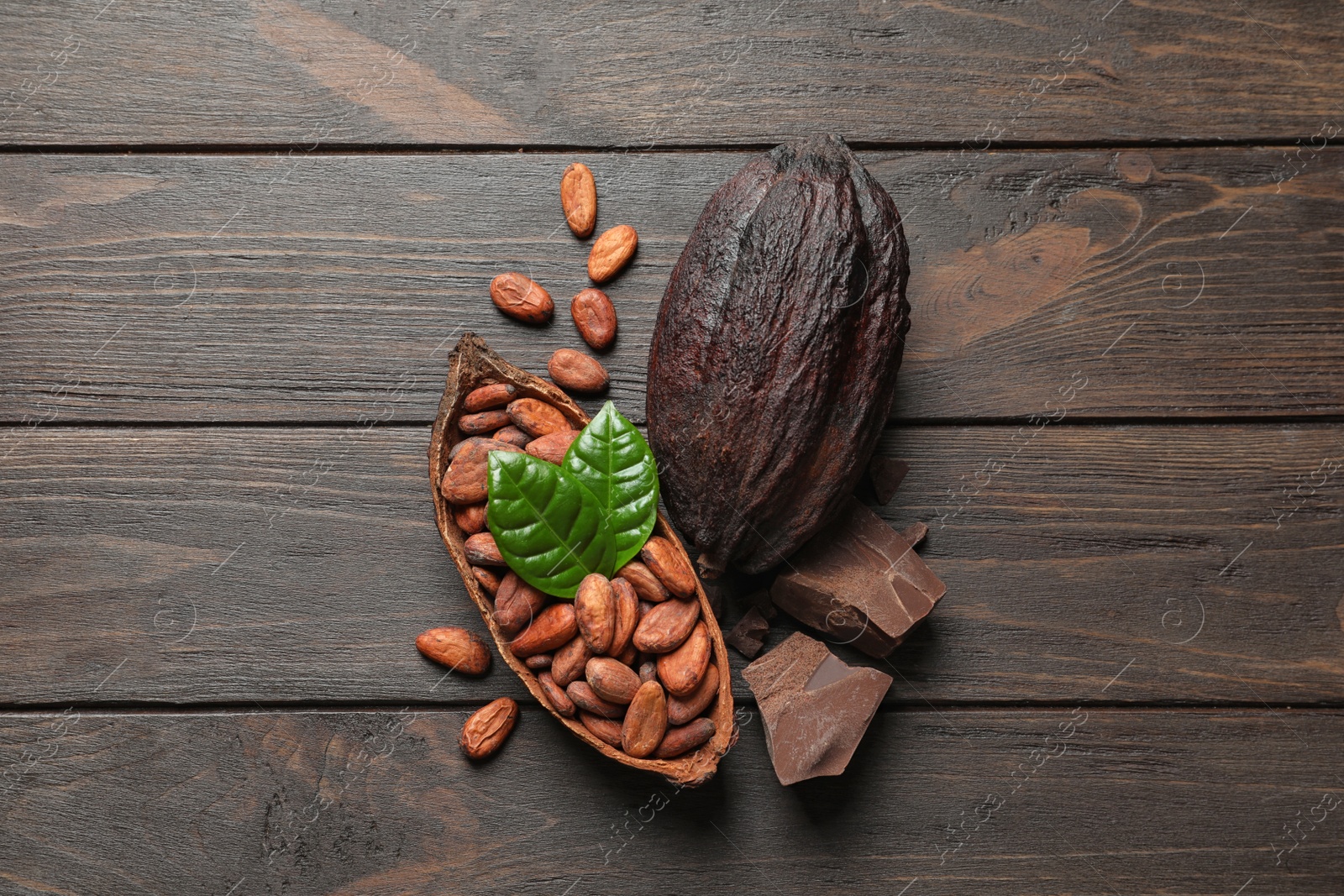 Photo of Flat lay composition with cocoa pods and chocolate on wooden table