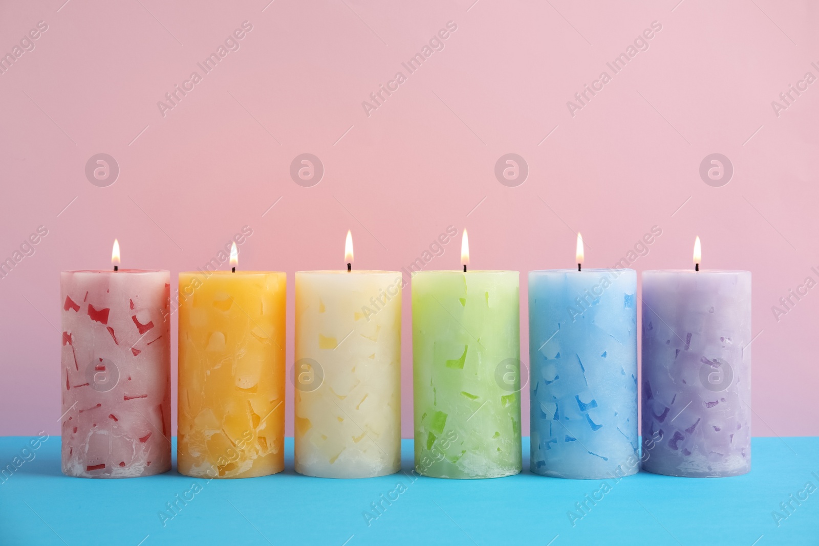 Photo of Alight scented wax candles on color background