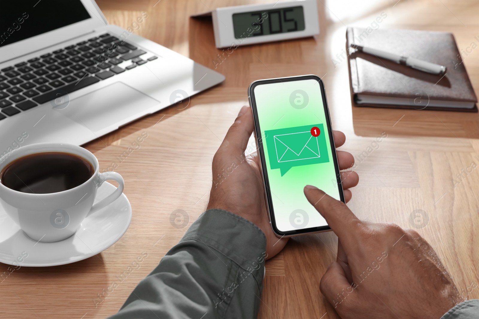 Image of Man checking new message on mobile phone at table, closeup