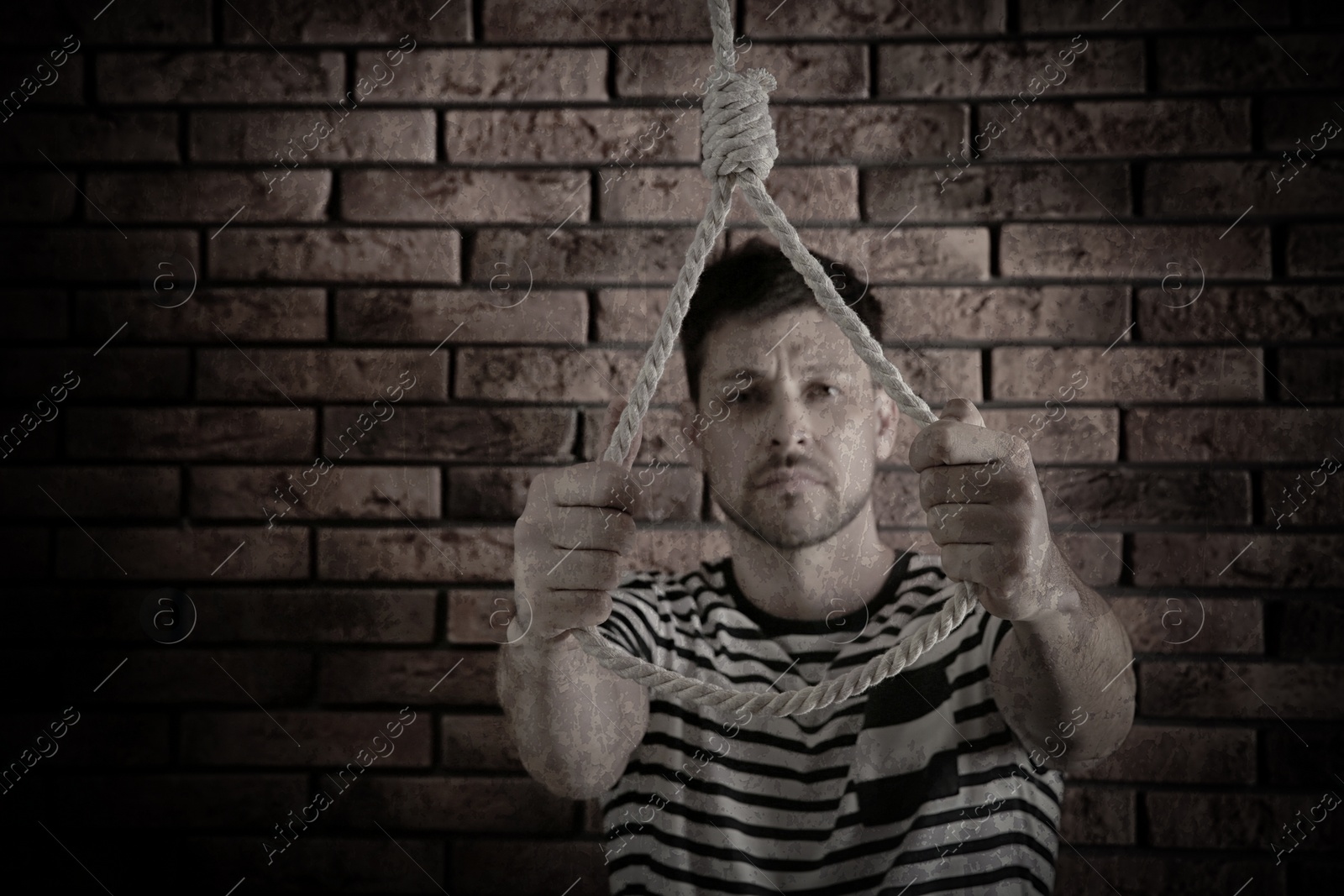 Image of Depressed man with rope noose near brick wall. Suicide concept