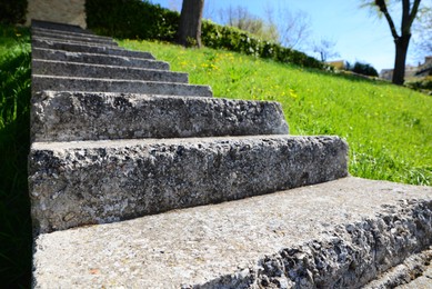 Photo of Stone stairs and green grass outdoors on sunny day, closeup