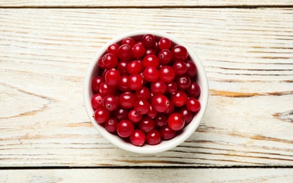 Photo of Tasty ripe cranberries on white wooden table, top view