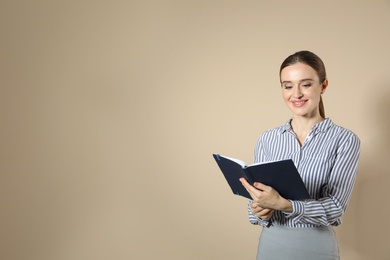 Portrait of young female teacher on beige background. Space for text