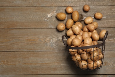 Raw fresh organic potatoes on wooden background, top view. Space for text