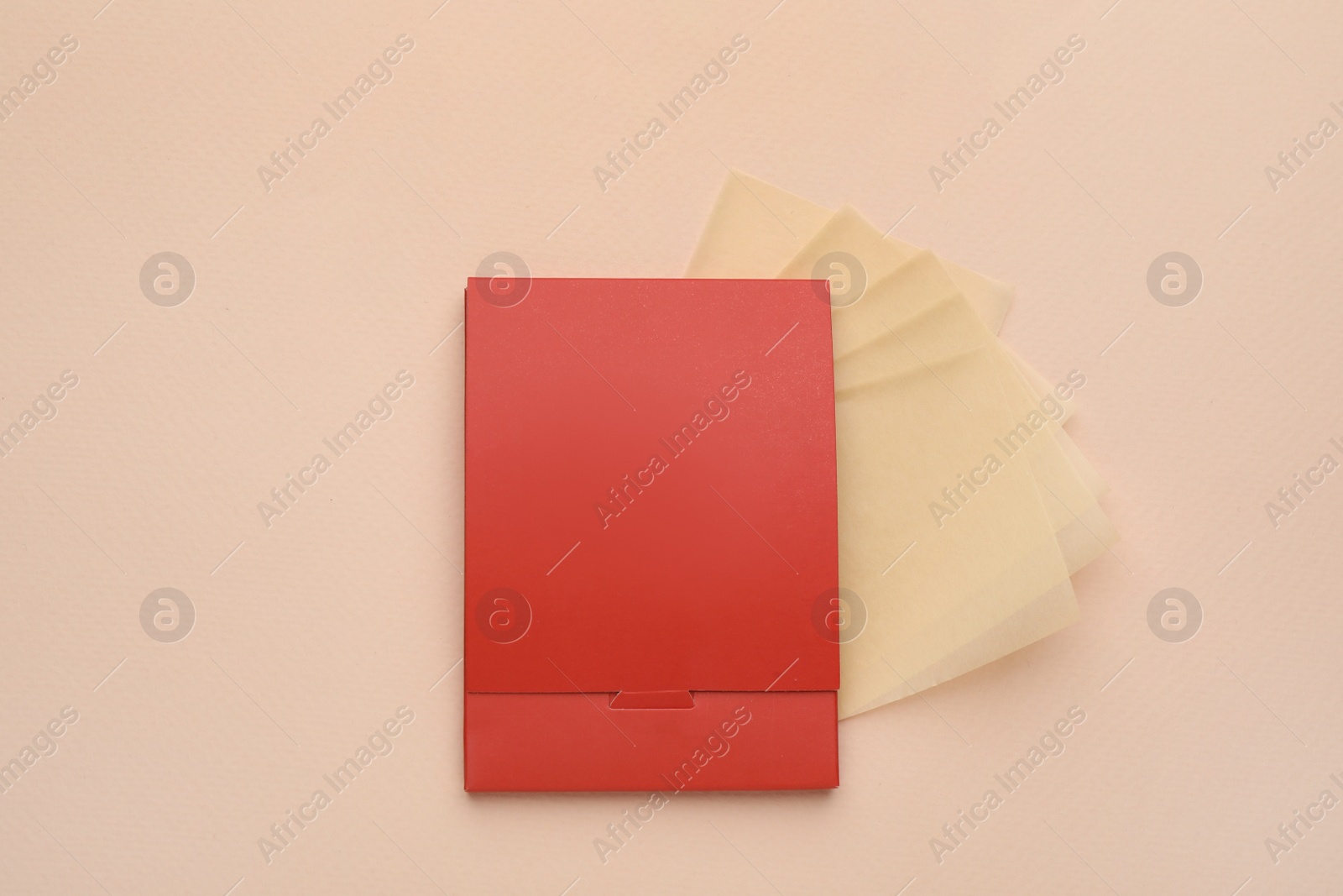 Photo of Package with facial oil blotting tissues on beige background, flat lay. Mattifying wipes