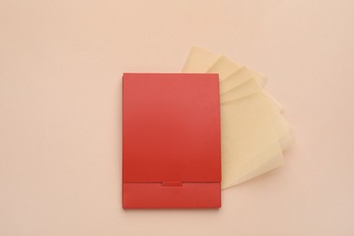 Photo of Package with facial oil blotting tissues on beige background, flat lay. Mattifying wipes