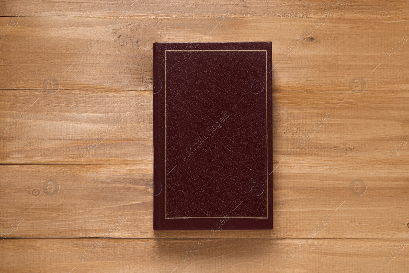 Photo of Old hardcover book on wooden table, top view