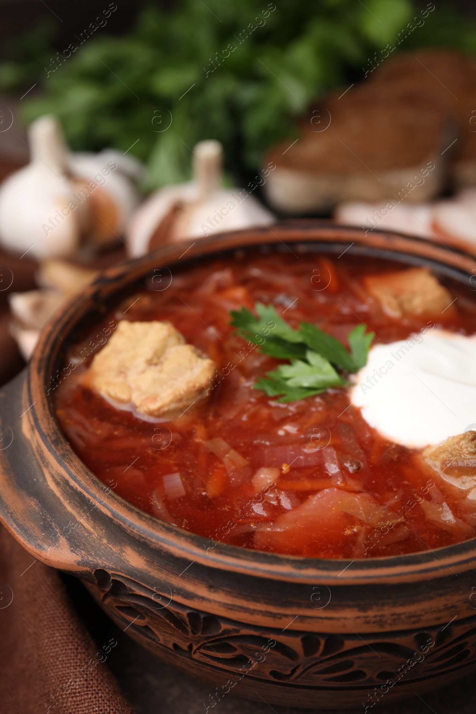 Photo of Tasty borscht with sour cream in bowl on table, closeup