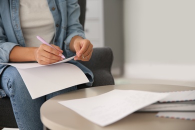 Woman writing letter at home, closeup view